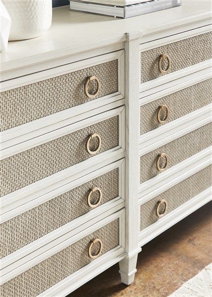 a white dresser with gold handles and drawers