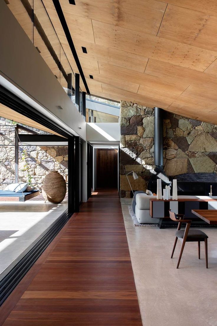 the interior of a modern house with wood and stone