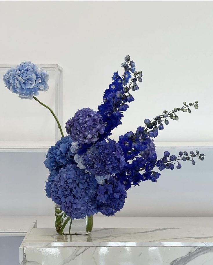 there is a vase with blue flowers in it