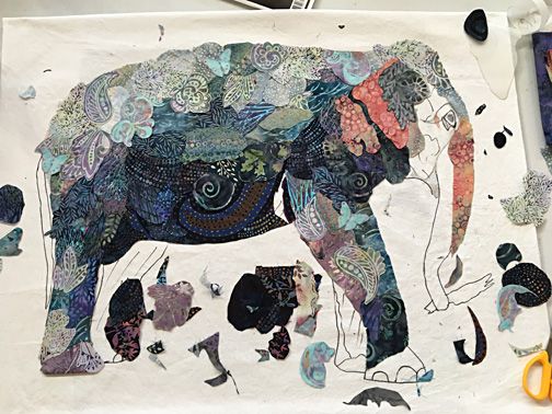 an elephant made out of paper on a table with scissors and other crafting supplies