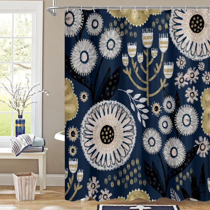 a blue shower curtain with white and gold flowers on it in front of a window