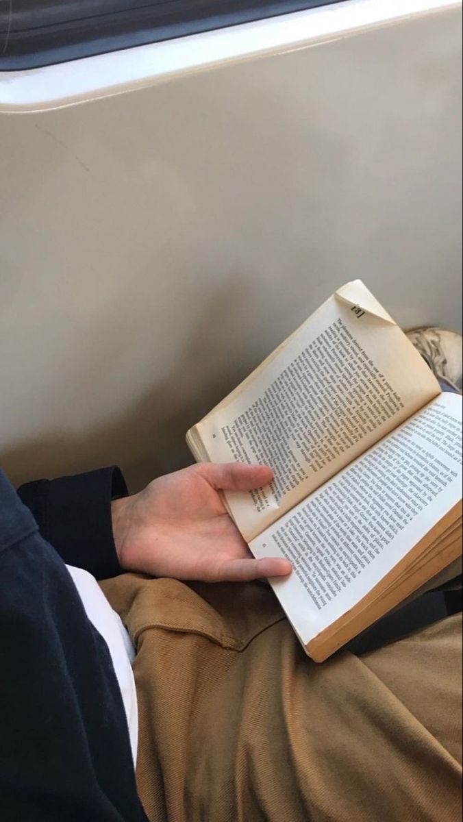 a person is reading a book on a train