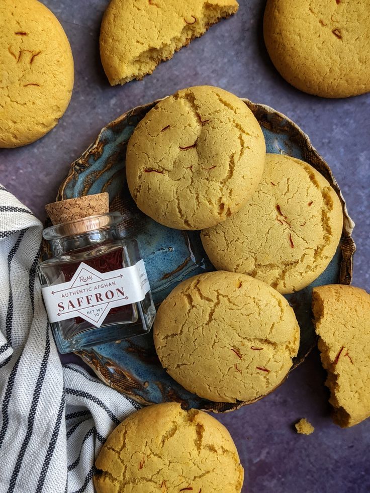 some cookies are sitting on a plate next to a jar of jam and a towel