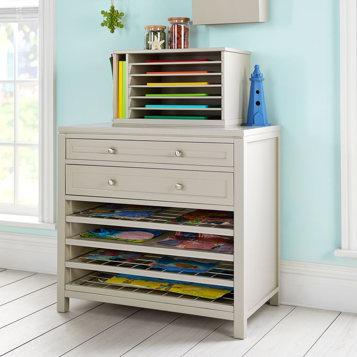 a white dresser with drawers in a blue room