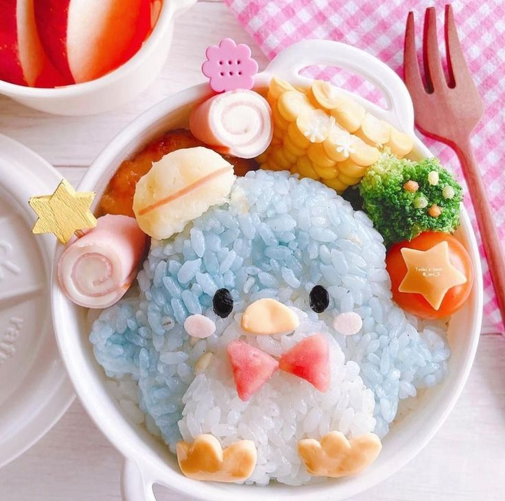 a white bowl filled with rice covered in fruit and veggies next to a fork