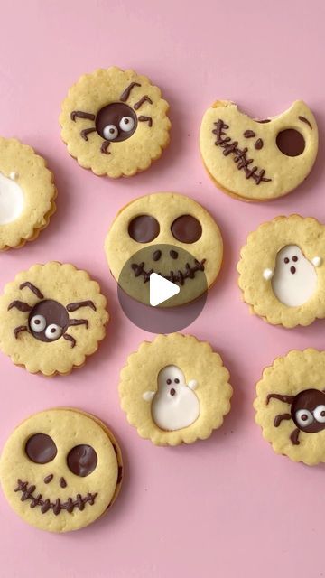 cookies decorated to look like halloween characters with eyes, nose and mouth on pink background