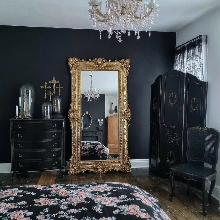 a bedroom with black walls and gold framed mirror, chandelier, dresser, and bed