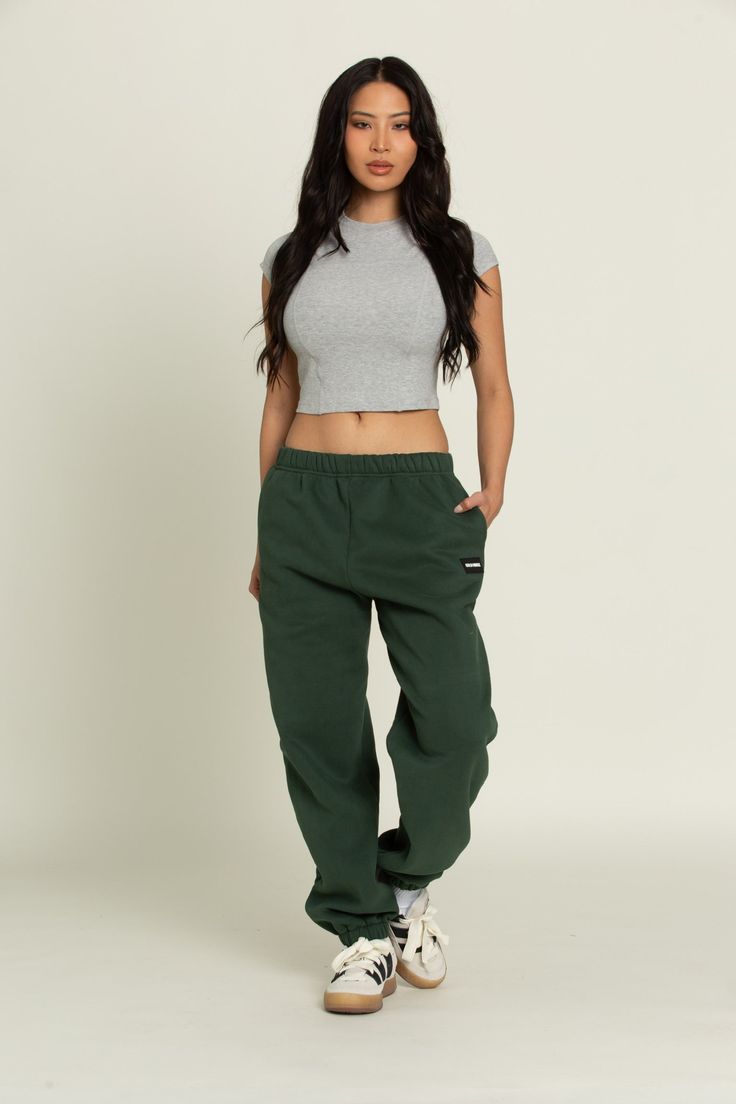 Elevate your athleisure style and feel like you're lounging on the go with our Hunter Green GH Jogger Sweatpants. The elastic waistband and tapered leg style allows you to feel secure and trendy. Complete with dual side pockets to keep your essentials close by. Pair with ur Hunter Green GH Cropped Hoodie to complete the set. Relaxed Fit Tapered Leg Parachute Pants Athleisure, Baggy Athleisure Joggers, Baggy Sporty Sweats For Loungewear, Sporty Sweats For Streetwear With Elastic Waistband, Sporty Streetwear Sweats With Elastic Waistband, Athleisure Joggers With Loosely Fitted Hips For Gym, Baggy Athleisure Activewear For Loungewear, Athleisure Joggers With Elastic Waistband For Streetwear, Baggy Athleisure Sweatpants