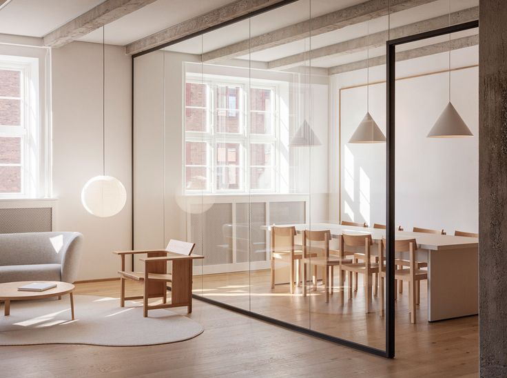 an empty room with glass walls and wooden furniture in the center, along with a round rug on the floor