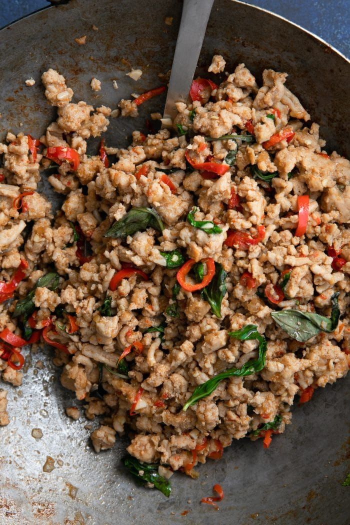 a pan filled with meat and veggies on top of a blue tablecloth