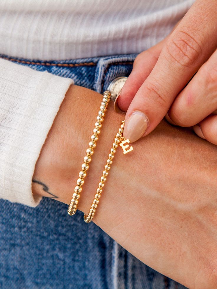 Make your stack personal with an Initial Charm! Wear your own initial, your children's, or a loved one's for a sentimental touch — or gift the heartwarming piece to someone you love. Designed with durability in mind, our gold-fill beads and charms are secured on extra-strength stretch cord to withstand your busy life and maintain their shine. Whether you dress them up, dress them down, or pile them on, you’ll truly never take them off. Beaded Name Bracelet, Bracelet Rosary, Everyday Stretches, Pyrite Bracelet, Layered Bracelet, Letter Bracelet, Bracelet Bead, Dainty Bracelet, Bracelet Dainty