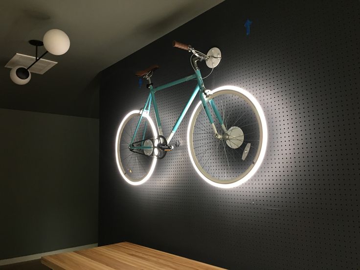 a bicycle mounted to the wall with lights around it