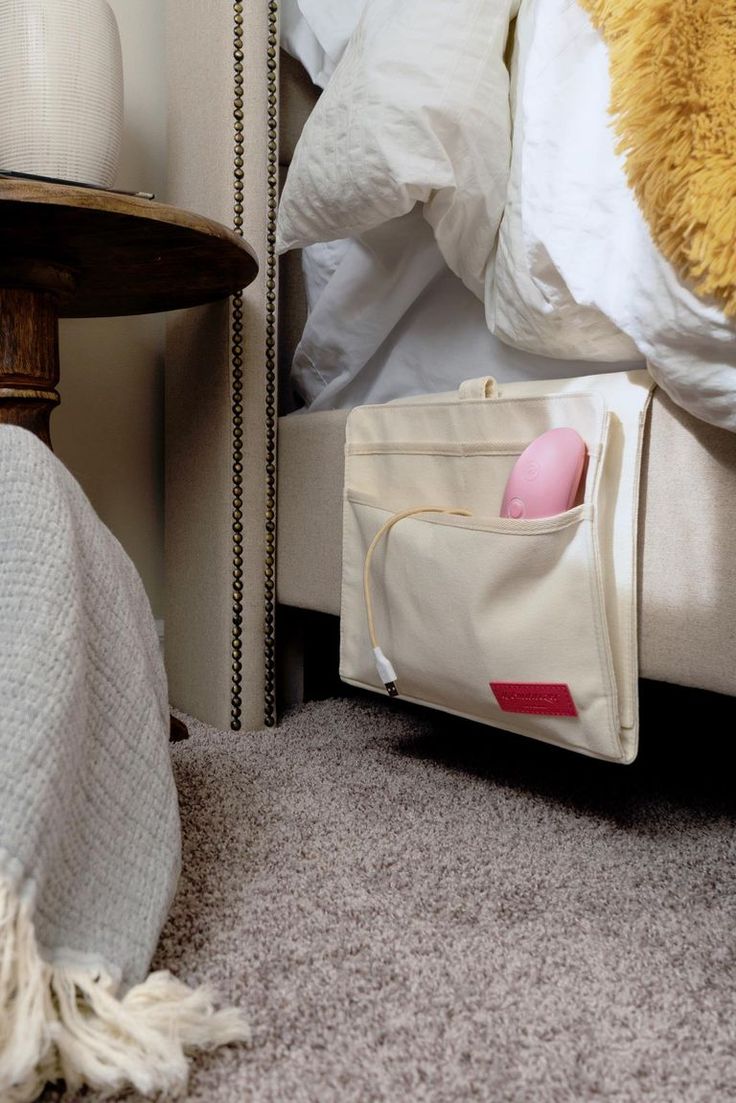 a white bag sitting on the floor next to a bed