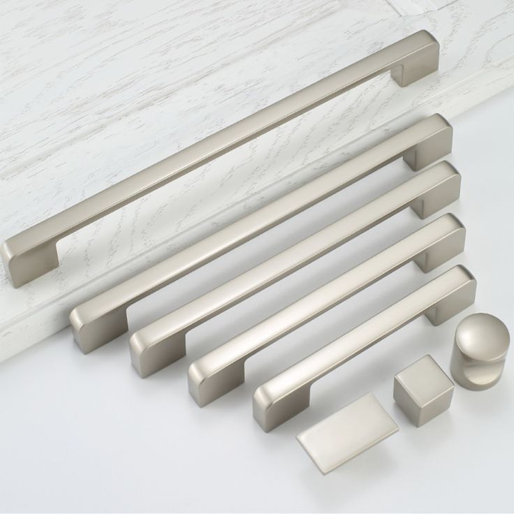 an assortment of handles and knobs on a white counter