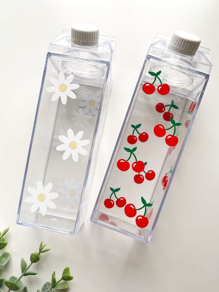 two water bottles with cherries and daisies on them