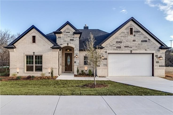 a brick and stone house with two garages