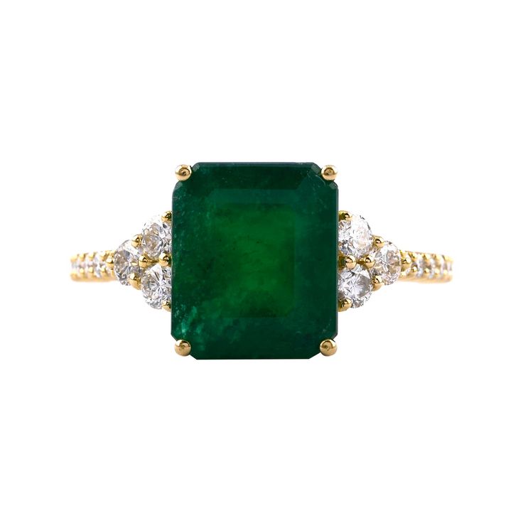 an emerald and diamond ring with two diamonds on the side, set in yellow gold