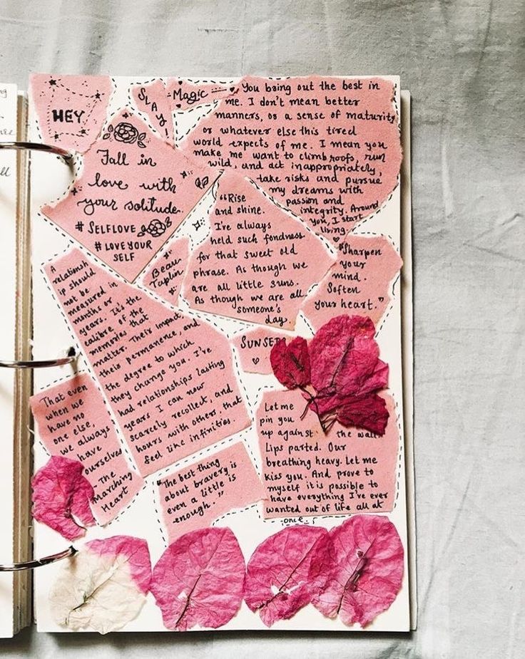 an open notebook with pink paper flowers and writing on the pages that read hey, i love you so much