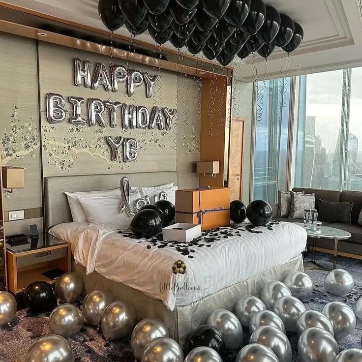 a bedroom decorated in black and silver balloons