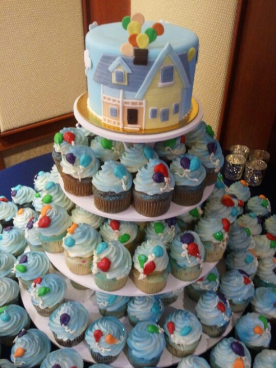 a three tiered cake with cupcakes on the bottom and one is blue