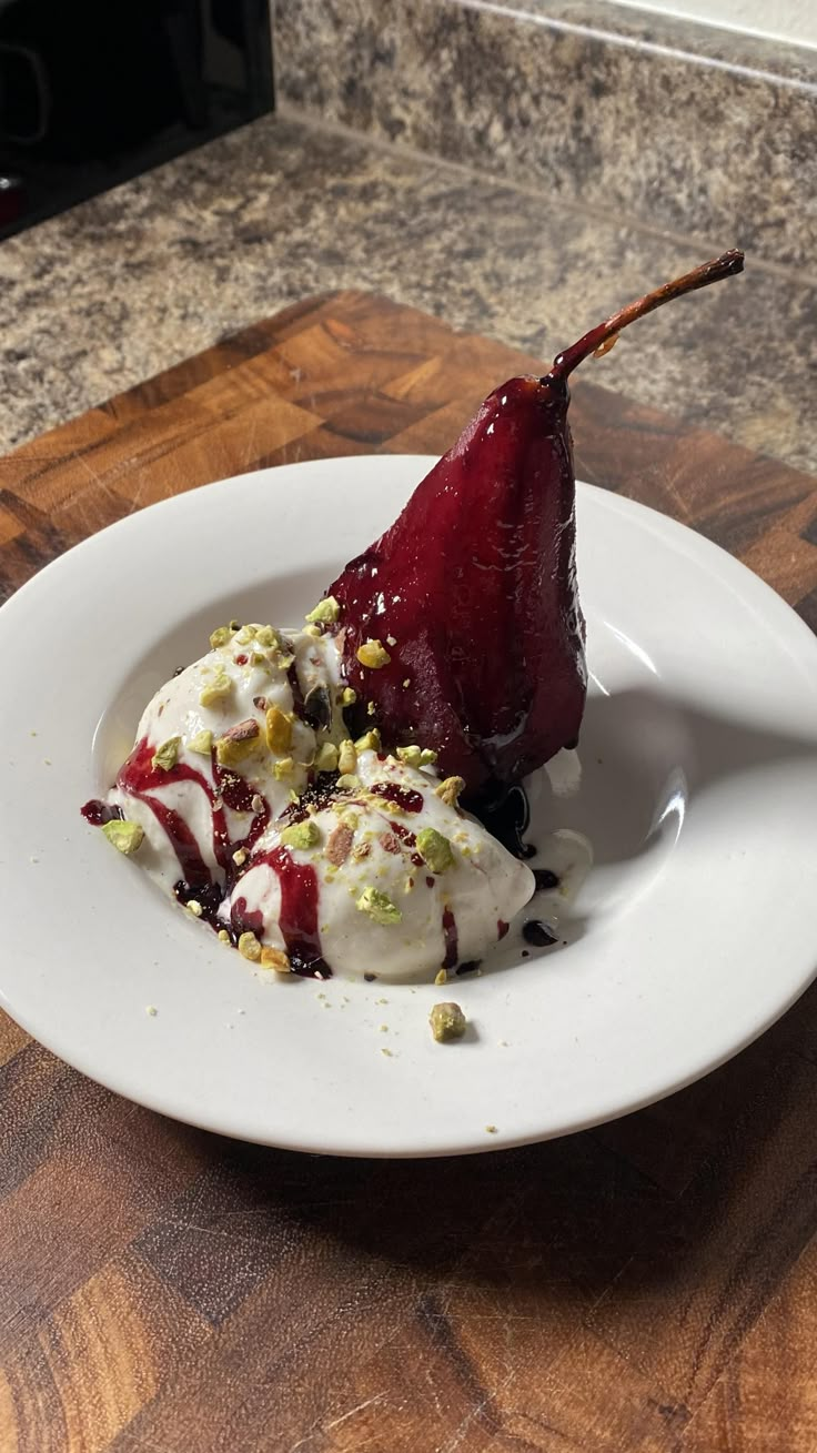 two pieces of fruit on a plate with ice cream and pistachio toppings