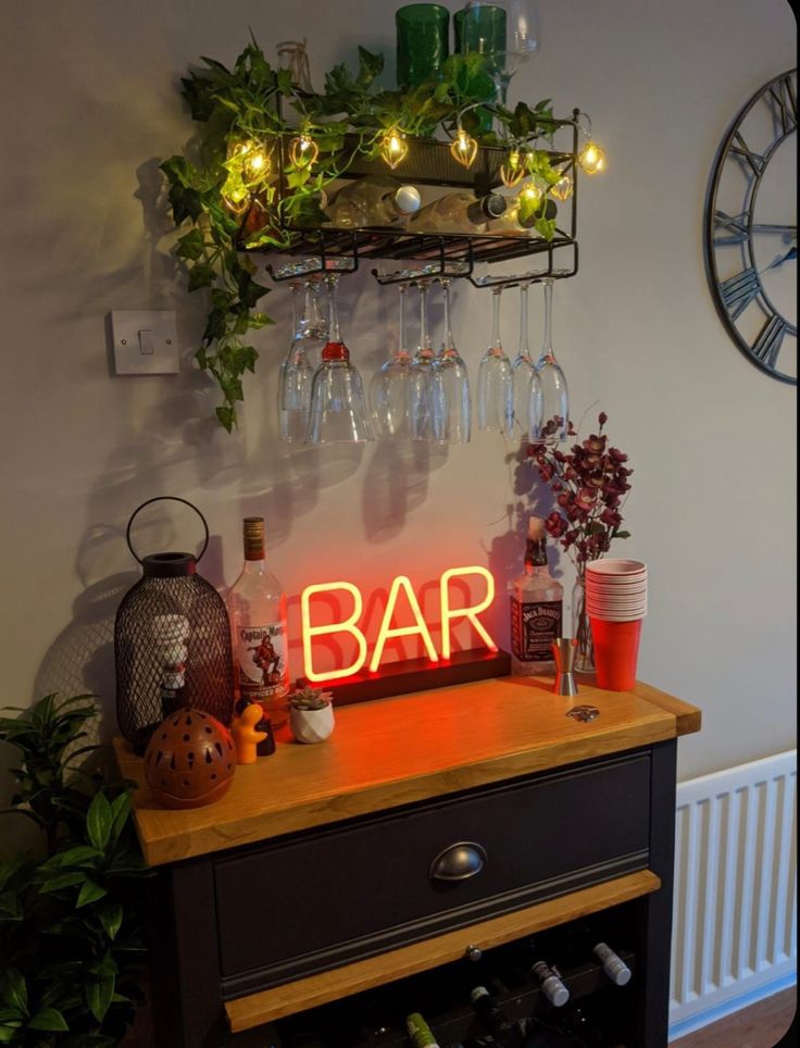 a bar sign sitting on top of a wooden table next to a wine glass rack