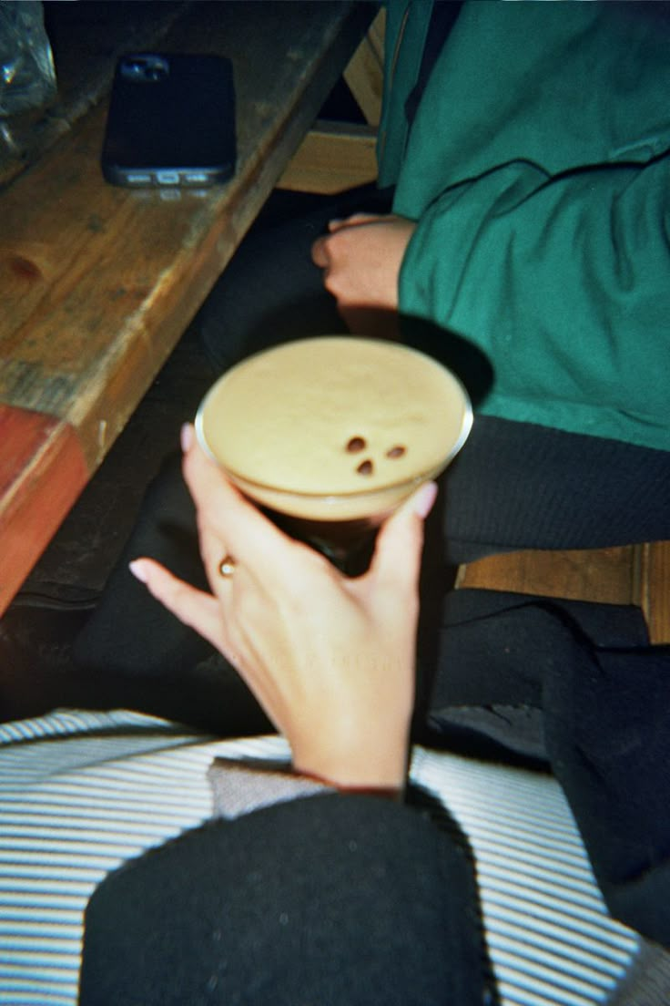 a person sitting down holding a plate with a button on it's side,