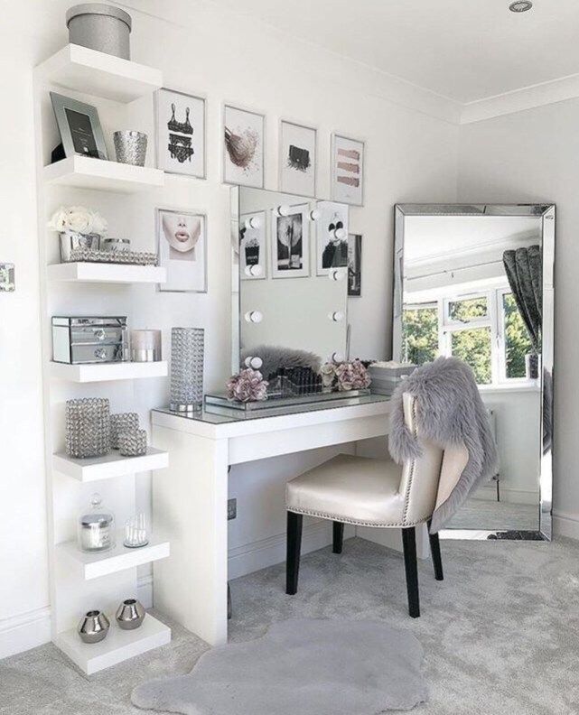 a white desk and chair in a small room with pictures on the wall above it