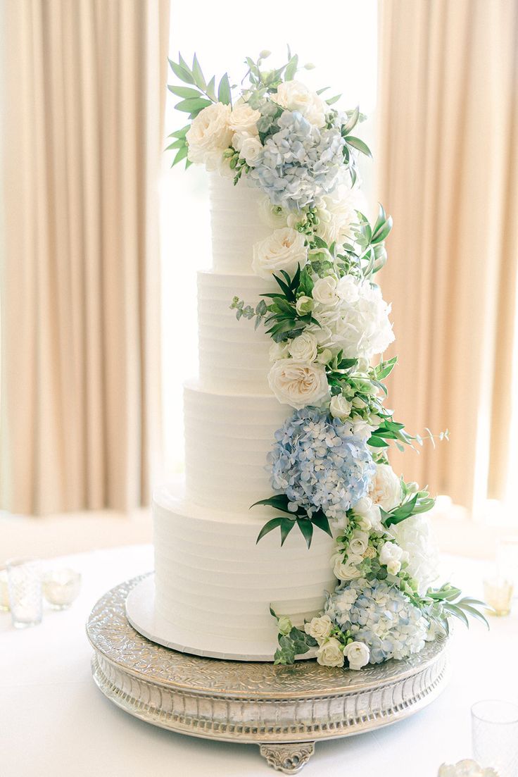 a white wedding cake with blue and white flowers