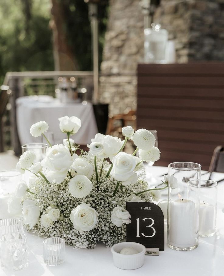 the table is set with white flowers and candles