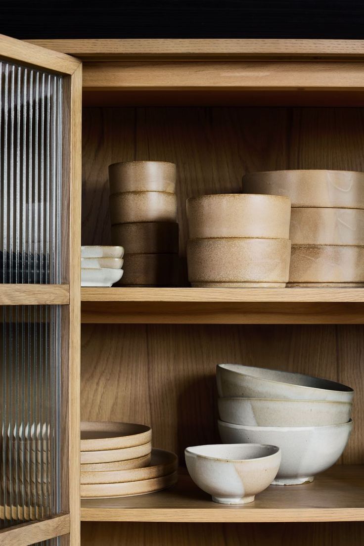 wooden shelves filled with bowls and plates on top of each other