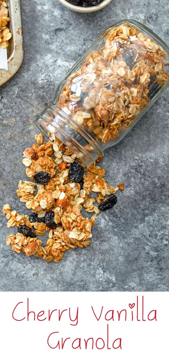 granola in a glass jar with raisins and blueberries on the side