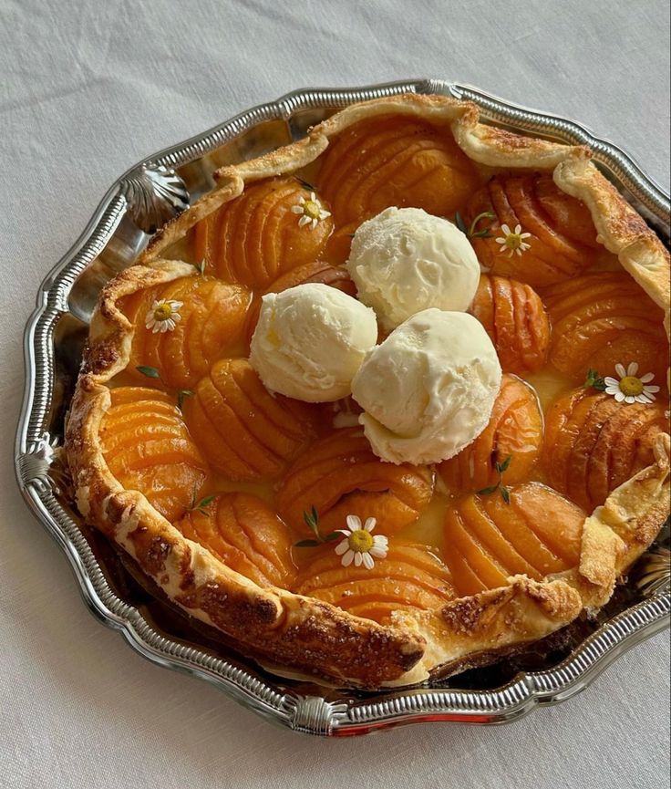 an apple pie with ice cream on top sits on a white cloth covered tablecloth