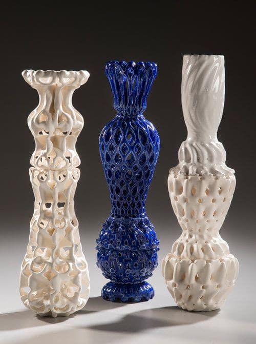 three different colored vases sitting next to each other