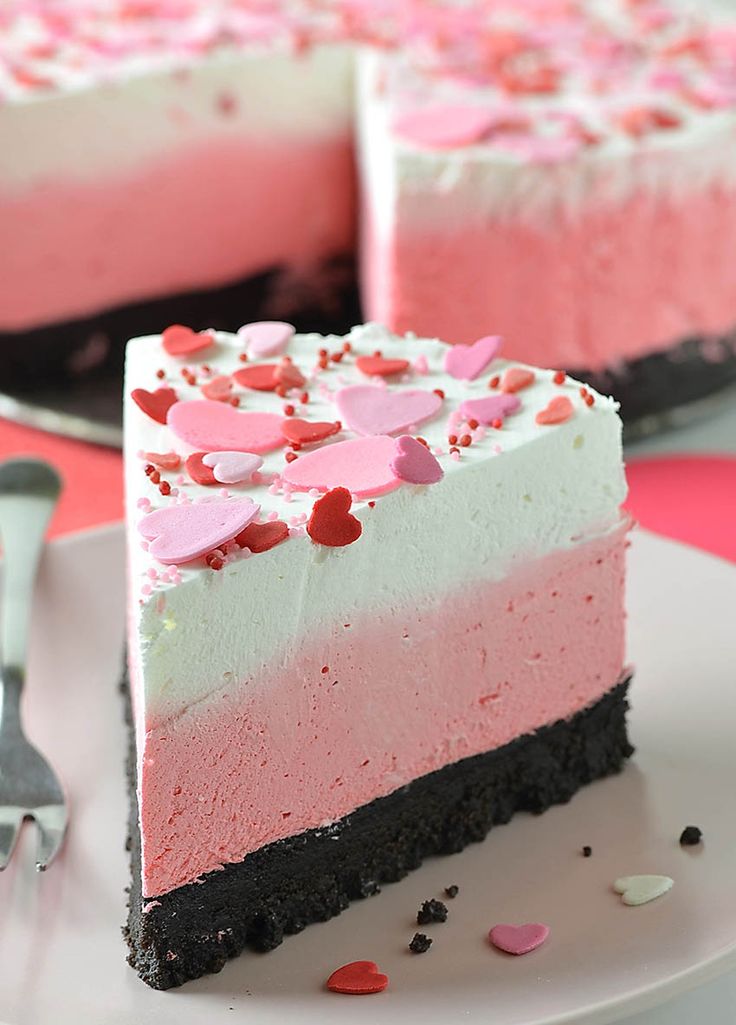 valentine's day cheesecake with pink and white frosting on a cake plate