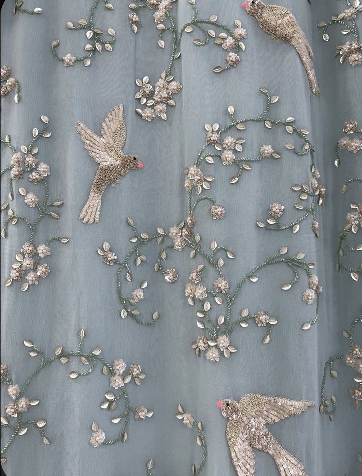 two birds on a blue fabric with white flowers