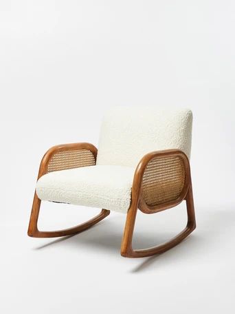 a wooden rocking chair with white upholstered fabric