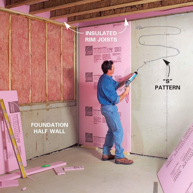 a man standing in front of a wall that is being insulated with pink foam