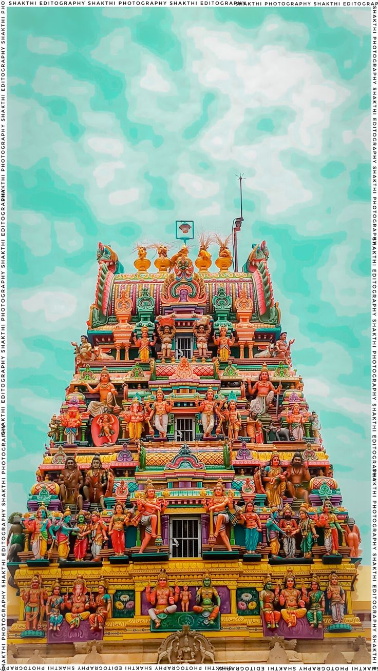 an elaborately decorated hindu temple with statues on the front and side walls, against a blue sky background