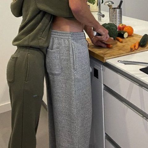 a woman standing in front of a kitchen counter cutting up vegetables on a cutting board