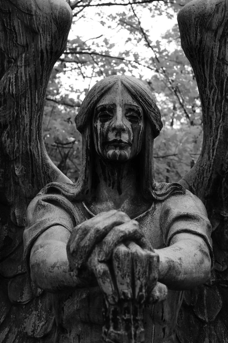 an angel statue with its arms crossed in front of it's face and hands