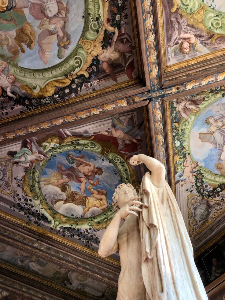 a statue in the middle of a room with painted ceilings