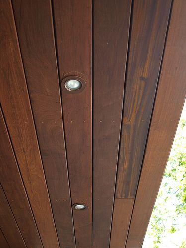 a cat sitting on top of a wooden porch