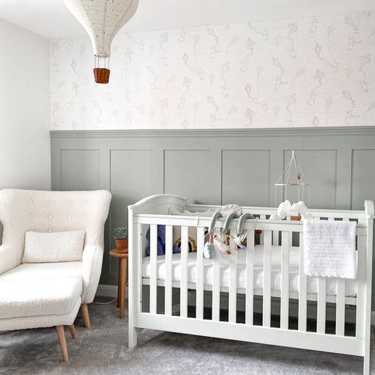 a baby's room with a white crib and rocking chair