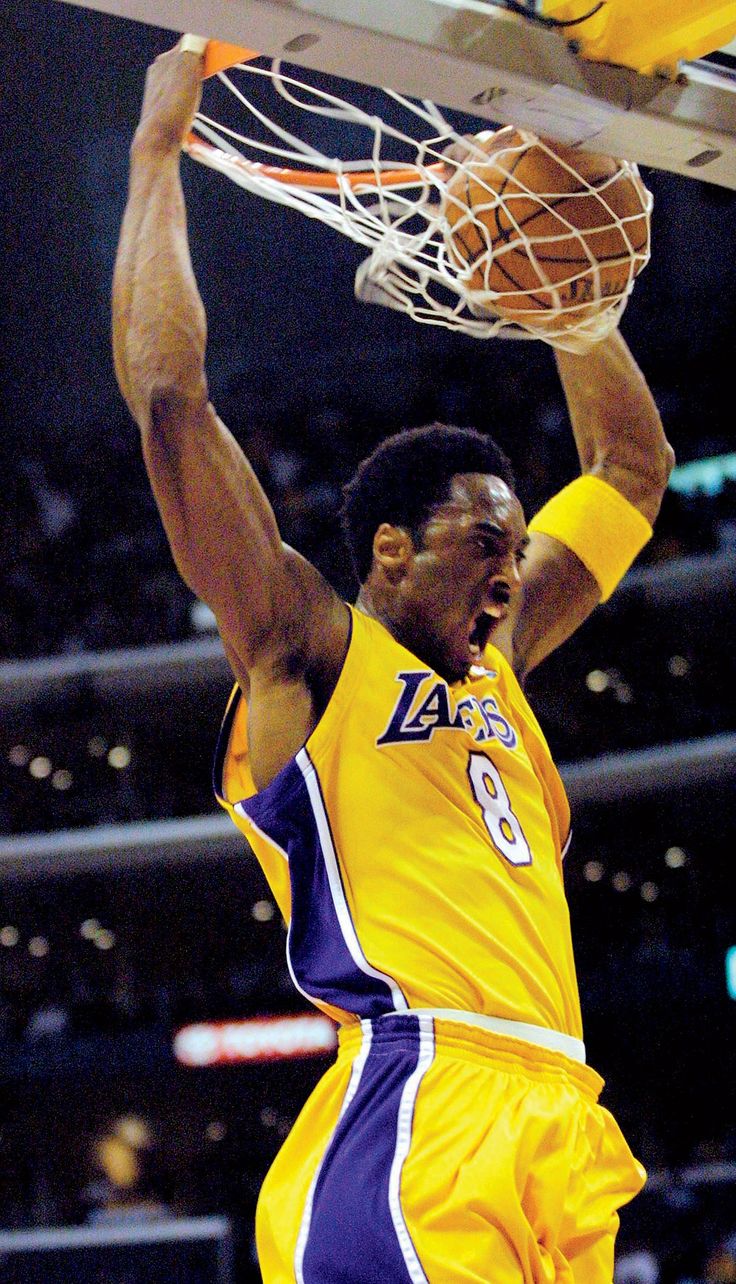 a basketball player is dunking the ball into the hoop with his hands in the air