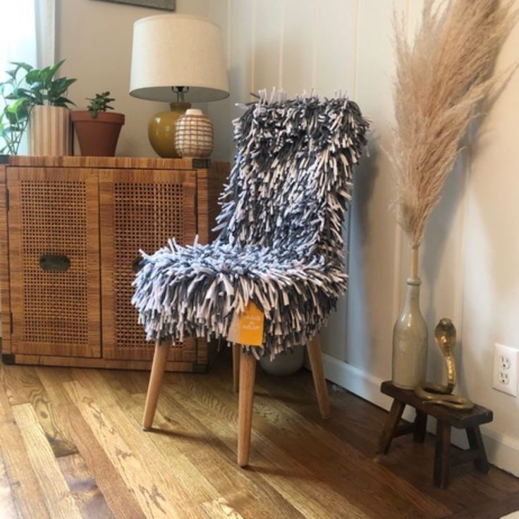 a chair sitting on top of a hard wood floor next to a basket filled with plants