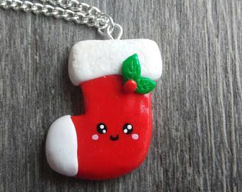 a red and white christmas stocking with a green leaf hanging from it's side