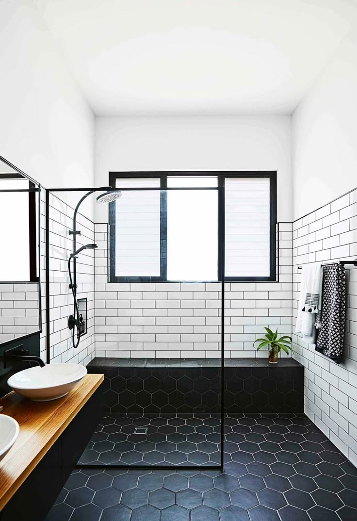 black and white bathroom with hexagonal tile flooring, wooden countertop, and double sinks