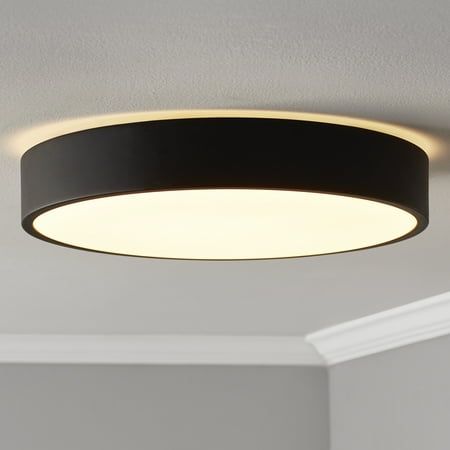 a circular light fixture hanging from the ceiling in a room with white walls and ceilings