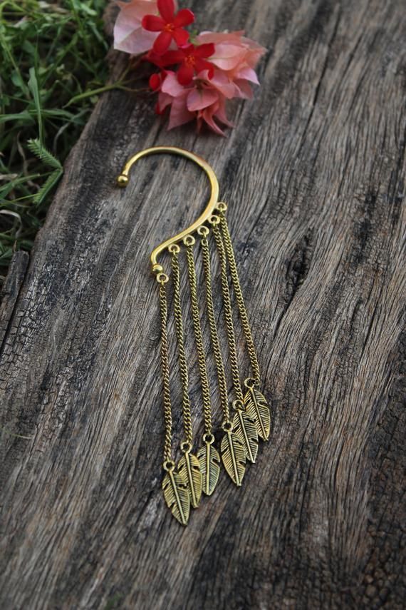 Sellers tip :  Buy more than 1 item from our shop to save shipping cost.Brass ear cuff with long chains with leaf charms add a tribal touch to your look.An original ear cuff no piercing required can be used for left or right ear.Note:- These are not stock photos – these are actual photos taken of the item listed. However, since screen resolutions vary, the colors “in-person” may be slightly different than you see on your monitor. If you have any questions – please feel free to send me a message. Bohemian Brass Body Jewelry For Festivals, Bohemian Dangle Body Jewelry For Festivals, Adjustable Festival Ear Cuff, Bohemian Brass Leaf Jewelry, Bohemian Leaf-shaped Brass Jewelry, Adjustable Gold Ear Cuff For Festivals, Bohemian Metal Dangle Body Jewelry, Gold Bohemian Wrap Earrings For Festivals, Bohemian Gold Wrap Earrings For Festival